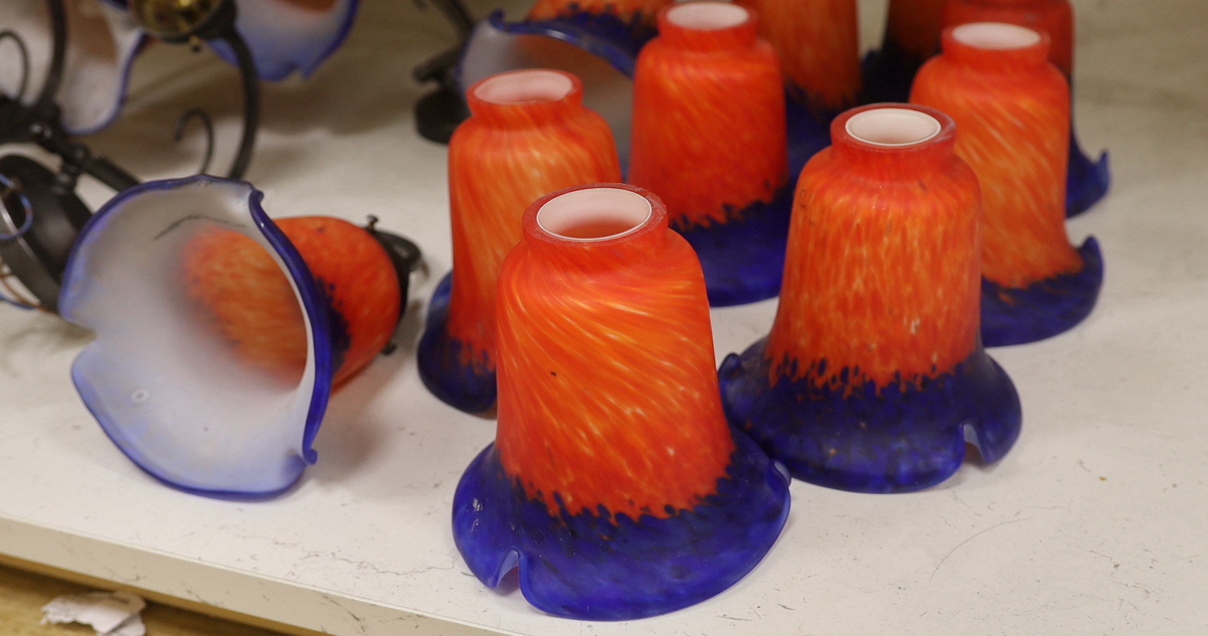 Four two branch metal wall lights with orange and blue glass shades and a set of six matching shades